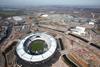 The stadium sits on its own island at the southern end of the Olympic Park. The Aquatics Centre and Orbit sculpture are to its right.