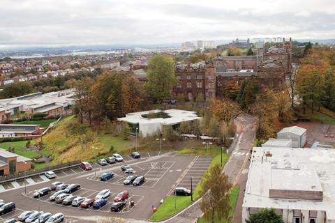 The building nestles into a sloping, wooded site beneath the gothic facade of the former Glasgow Royal Lunatic Asylum.