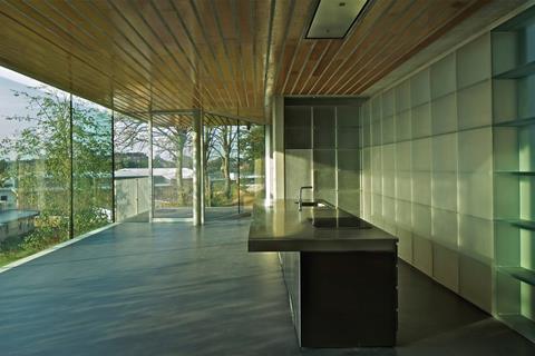 The south-facing kitchen is framed by a cast resin storage wall by Vincent de Rijk.