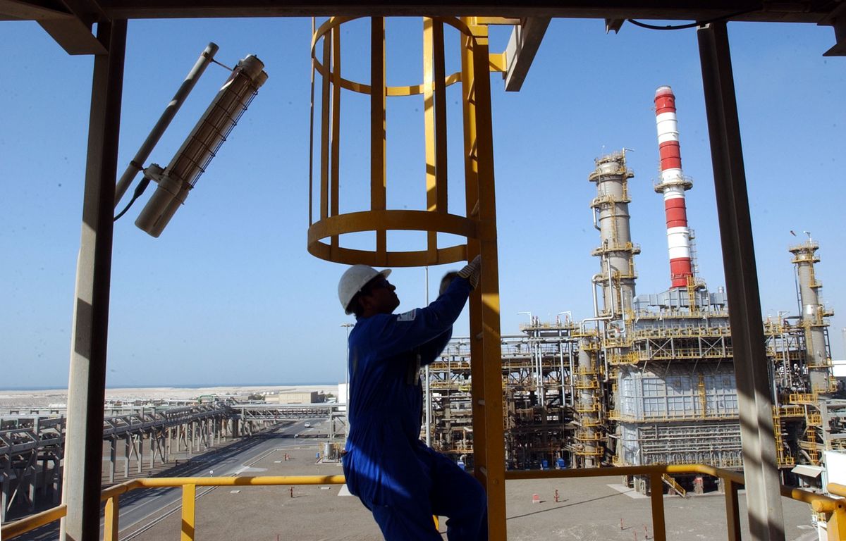 Savio Menezes, a refinery operator climbs as he works at an oil processing plant in Jebel Ali Free Zone in Dubai, United Arab Emirates, Thursday June 3, 2004. (KEYSTONE/AP Photo/Kamran Jebreili)