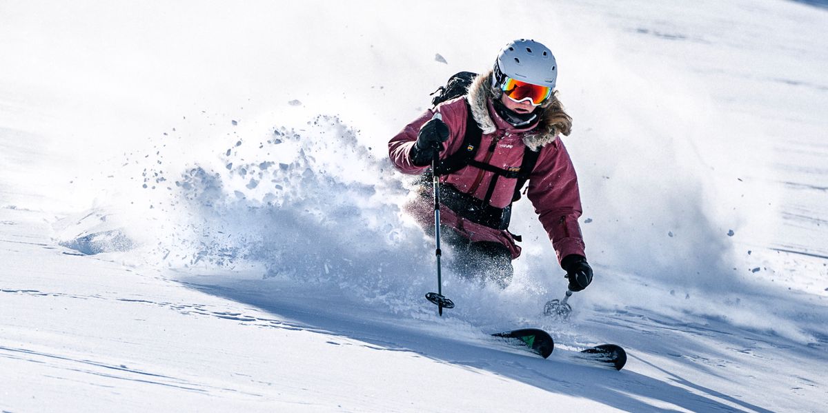 Female skier doing a turn in deep snow.