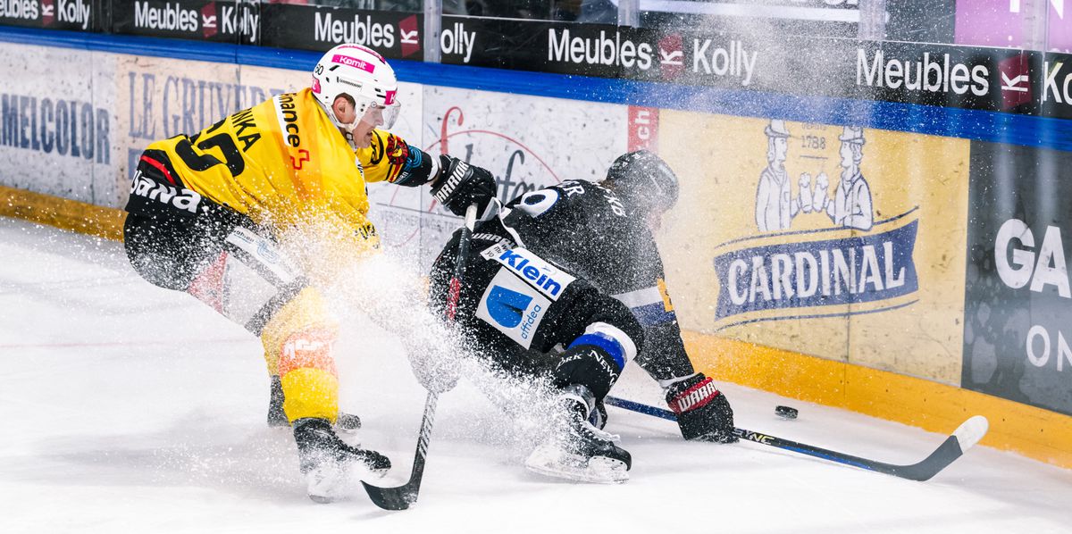 $, gauche, lutte pour le puck avec $, droite, lors du match du championnat suisse de hockey sur glace de National League entre le HC Fribourg-Gotteron, HCFG, et le SC Bern, SCB, ce lundi 4 mars 2024, a la patinoire de la BCF Arena a Fribourg. (KEYSTONE/Adrien Perritaz)